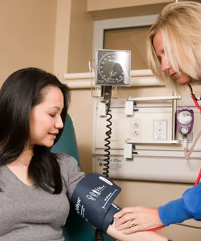 a doctor checking a woman's blood pressure