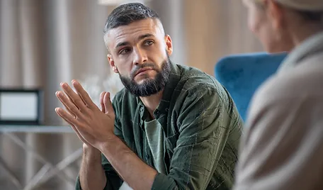 a man with a beard sitting at a table with another man