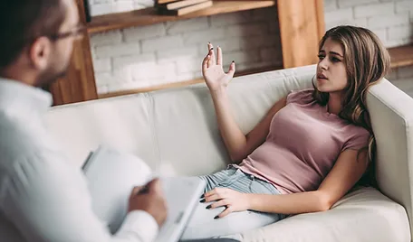 a woman lying on a couch with her hand raised