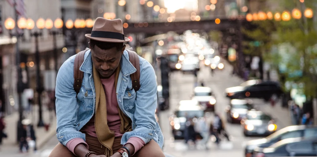 a man sitting on a bench in a city