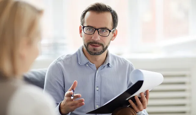 a man holding a piece of paper and a pen