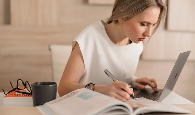 a woman writing on a laptop