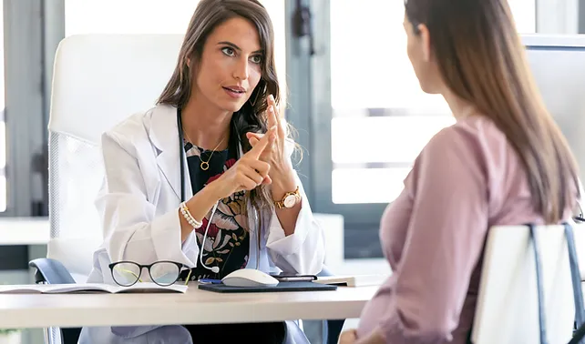 a doctor in a white coat talking to a woman